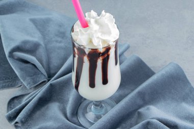 Havlunun yanında bir bardak milkshake, mavi arka planda. Yüksek kalite fotoğraf