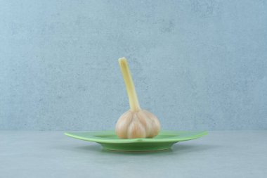 Gri arka planda bir tabak çiğ sarımsak. Yüksek kalite fotoğraf