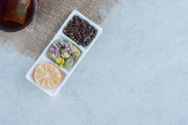 Bir fincan çayın yanında dilimlenmiş bir kase limon ve mermer zemin üzerinde havlunun üzerinde yapraklar. Yüksek kalite fotoğraf