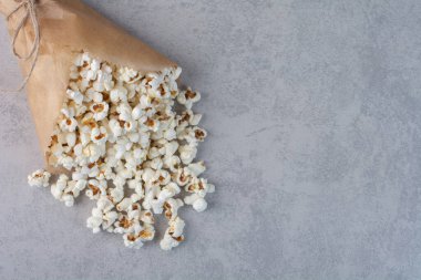 Mermer zemine sarılı kağıtta patlamış mısır servisi. Yüksek kalite fotoğraf