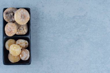 Mermer arka planda, kasede iki çeşit kurutulmuş meyve var. Yüksek kalite fotoğraf