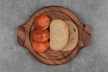 Tahta üzerinde ekmek dilimleri olan kızarmış salam. Yüksek kalite fotoğraf