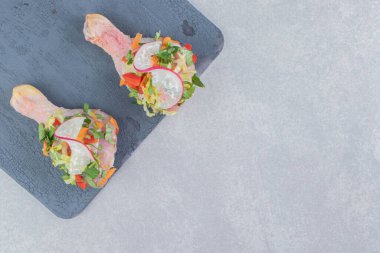 Tahtada, mermer zeminde marine edilmiş tavuk budu var. Yüksek kalite fotoğraf