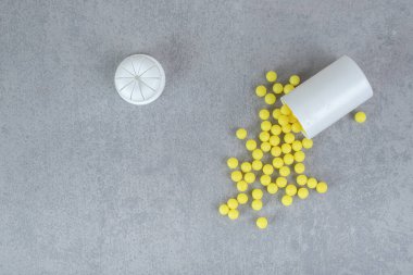 Gri arka planda küçük beyaz bir kavanoz askorbik asit hapı. Yüksek kalite fotoğraf