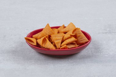 Kırmızı kasedeki acılı cipslerin yakın plan fotoğrafını çek. Yüksek kalite fotoğraf