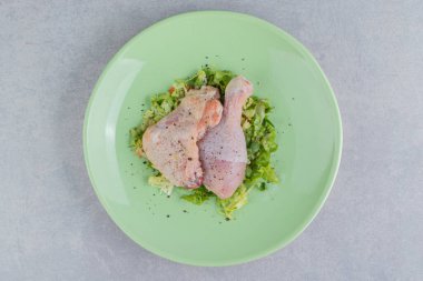 Tabakta salamura edilmiş iki tavuk bacağı, beyaz arka planda. Yüksek kalite fotoğraf