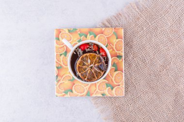 Portakal dilimleri ve çuval bezinde gül kalçalarıyla bir fincan çay. Yüksek kalite fotoğraf