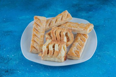 Mavi arka planda, tabağında reçel olan tatlı kurabiyeler. Yüksek kalite fotoğraf