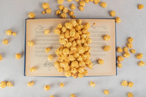 Book Heap Caramel Coated Popcorn Scattered All Marble Background High — Stock Photo, Image