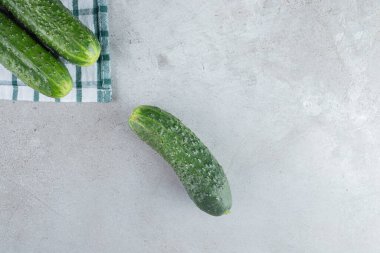 Masa örtüsünde üç taze salatalık izole edilmiş. Yüksek kalite fotoğraf