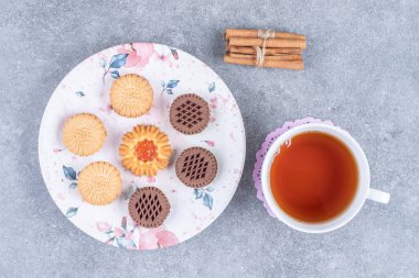 Tabakta çeşitli bisküviler ve bir fincan sıcak çay. Yüksek kalite fotoğraf