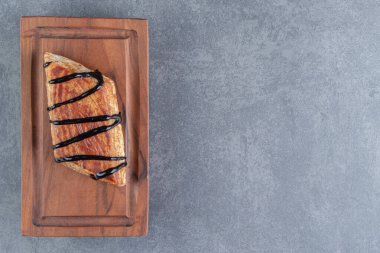 Tahta bir tahtanın üzerinde lezzetli bir üçgen pasta. Yüksek kalite fotoğraf