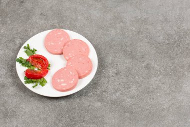 Beyaz tabakta dilimlenmiş salam ve domates. Yüksek kalite fotoğraf