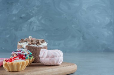 Kekler, kurabiyeler, marmelatlar ve mermer zemin üzerinde küçük bir pasta. Yüksek kalite fotoğraf