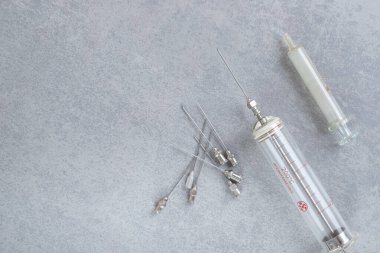 Gri arka planda iğneleri olan eski bir şırınga. Yüksek kalite fotoğraf