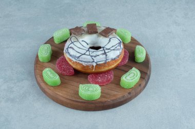 Marmelade, mermer zemin üzerinde çikolata parçalı donut etrafında daire çiziyor. Yüksek kalite fotoğraf