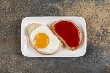 Kızarmış yumurtalı tost ve beyaz tabakta reçel. Yüksek kalite fotoğraf