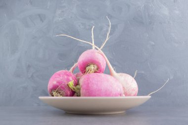 Mermer arka plandaki tabakta taze turplar. Yüksek kalite fotoğraf