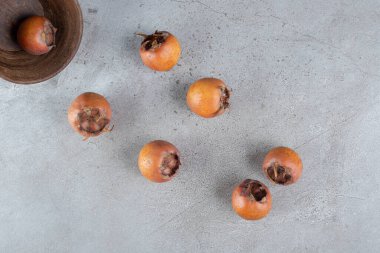 Gri arka planda hurmalarla dolu ahşap bir kase. Yüksek kalite fotoğraf