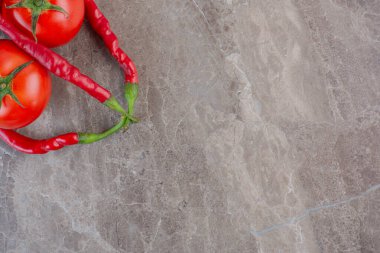 Mermer arka planda sıralanmış domates ve kırmızı biber. Yüksek kalite fotoğraf