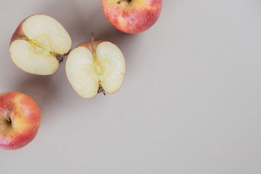 Tam ve dilimlenmiş elmalar mermer arka planda sergileniyor. Yüksek kalite fotoğraf