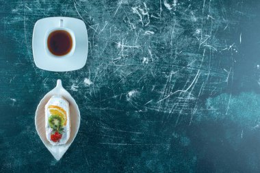 Bir parça kremalı kek ve bir fincan sıcak çay. Yüksek kalite fotoğraf