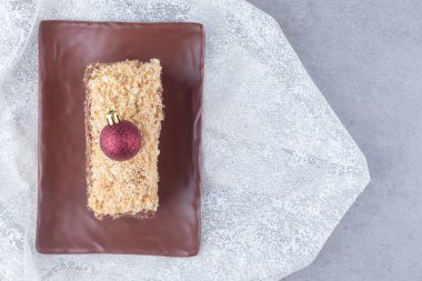 Bir tepside pasta dilimi, mermer arka plandaki masa örtüsünün üzerinde de incik boncuk. Yüksek kalite fotoğraf