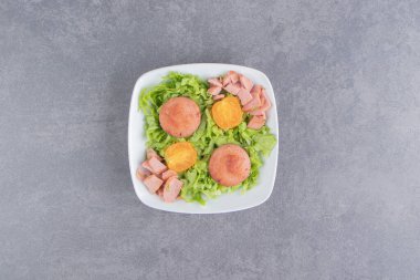 Marul yaprakları ve sosis tabakta, mermer zemin üzerinde. Yüksek kalite fotoğraf