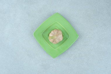 Gri arka planda bir tabak çiğ sarımsak. Yüksek kalite fotoğraf