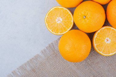 Taze portakallar beyaz arka plandaki çuval bezinin üzerinde yatıyor. Yüksek kalite fotoğraf