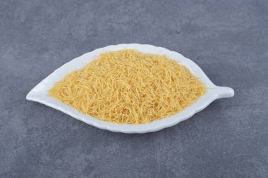 Yaprak şeklinde tabakta bir yığın çiğ makarna. Yüksek kalite fotoğraf