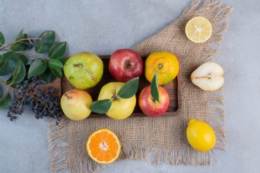 Tahtada çeşitli meyveler ve mermer zeminde bir parça kumaş. Yüksek kalite fotoğraf