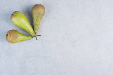 Gri arka planda üç taze yeşil armut. Yüksek kalite fotoğraf