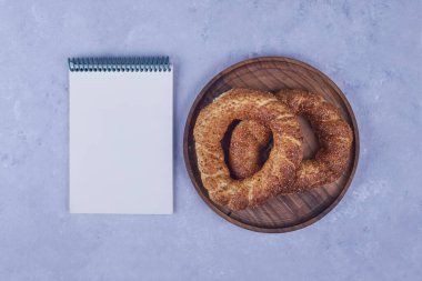 Tahta bir tabakta fatura defteriyle Türk simit 'i. Yüksek kalite fotoğraf