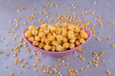 Mermer zemine saçılmış mısır taneleriyle karamelli patlamış mısır servisi. Yüksek kalite fotoğraf