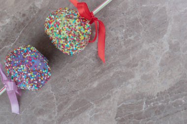 Lolipoplar mermer arka planda kurdelelerle süslenmiş. Yüksek kalite fotoğraf