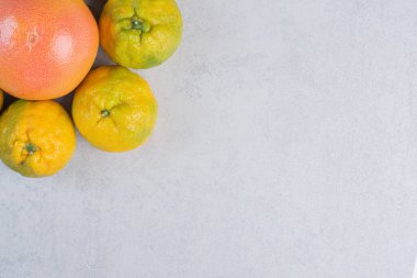 Mandalina (portakallar, mandalinalar, turunçgil meyveleri) fotoğraflarını gri arkaplanda kapat. Yüksek kalite fotoğraf