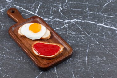 Reçel ve sahanda yumurta tahtada, mermer zemin üzerinde iki dilim ekmek. Yüksek kalite fotoğraf