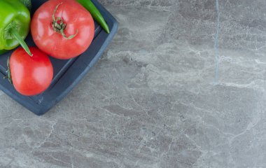 Tepside domates ve biber var, mermer arka planda. Yüksek kalite fotoğraf