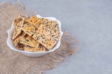 Susam kaplı ekmek dilimleri mermer zemin üzerinde bir parça kumaş üzerinde bir kase içinde. Yüksek kalite fotoğraf