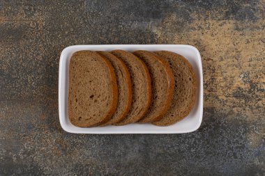 Beyaz kare tabakta dilimlenmiş siyah çavdar ekmeği. Yüksek kalite fotoğraf