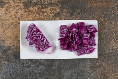 Mermer arka planda, kasede ince doğranmış lahana parçasının yanında bir parça lahana. Yüksek kalite fotoğraf