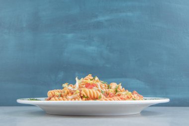 Beyaz bir tabak otlu sarmal makarna. Yüksek kalite fotoğraf