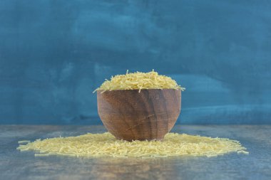 Vermicelli makarnası mermer arka planda, dolu bir kaseden yayılmış. Yüksek kalite fotoğraf