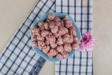 Bir kase patlamış mısır şekeri ve mermer arka planda çiçek korollasının altına havlu koy. Yüksek kalite fotoğraf