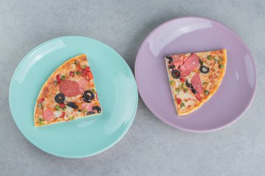 Mermer zemin üzerinde pizza dilimleri olan iki tabak. Yüksek kalite fotoğraf