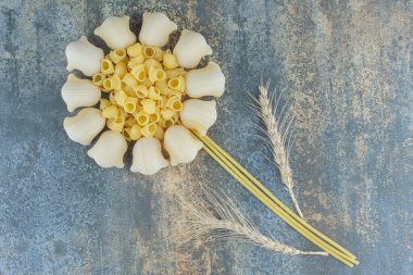 Mermer zemin üzerinde, makarnalar ve buğday başaklarından yapılmış bir çiçek. Yüksek kalite fotoğraf