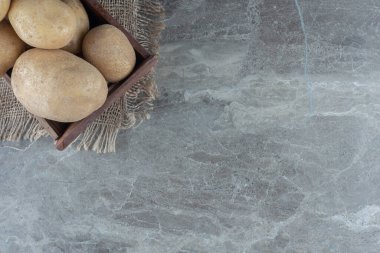 Patatesler kutuda, havlunun üstünde, mermer zeminde. Yüksek kalite fotoğraf
