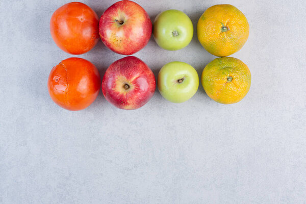 Сезонные свежие фрукты на сером фоне. Высокое качество фото