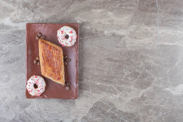 大理石の背景に大皿に小さなケーキ コーヒー豆と一口サイズのドーナツ 高品質の写真 — ストック写真